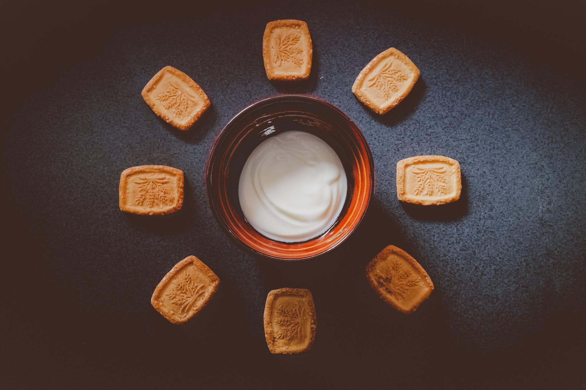 white sauce on bowl with biscuits on side